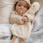 Baby in a cozy setting with Quacks the Comforter Toy