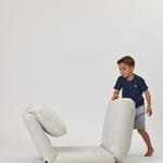 Child playing with a Rylee Recliner on a white background