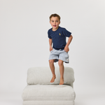 Child standing on a Rylee Recliner on a white background