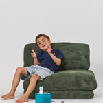 Child sitting on Forest Rylee Recliner on with toys on the floor