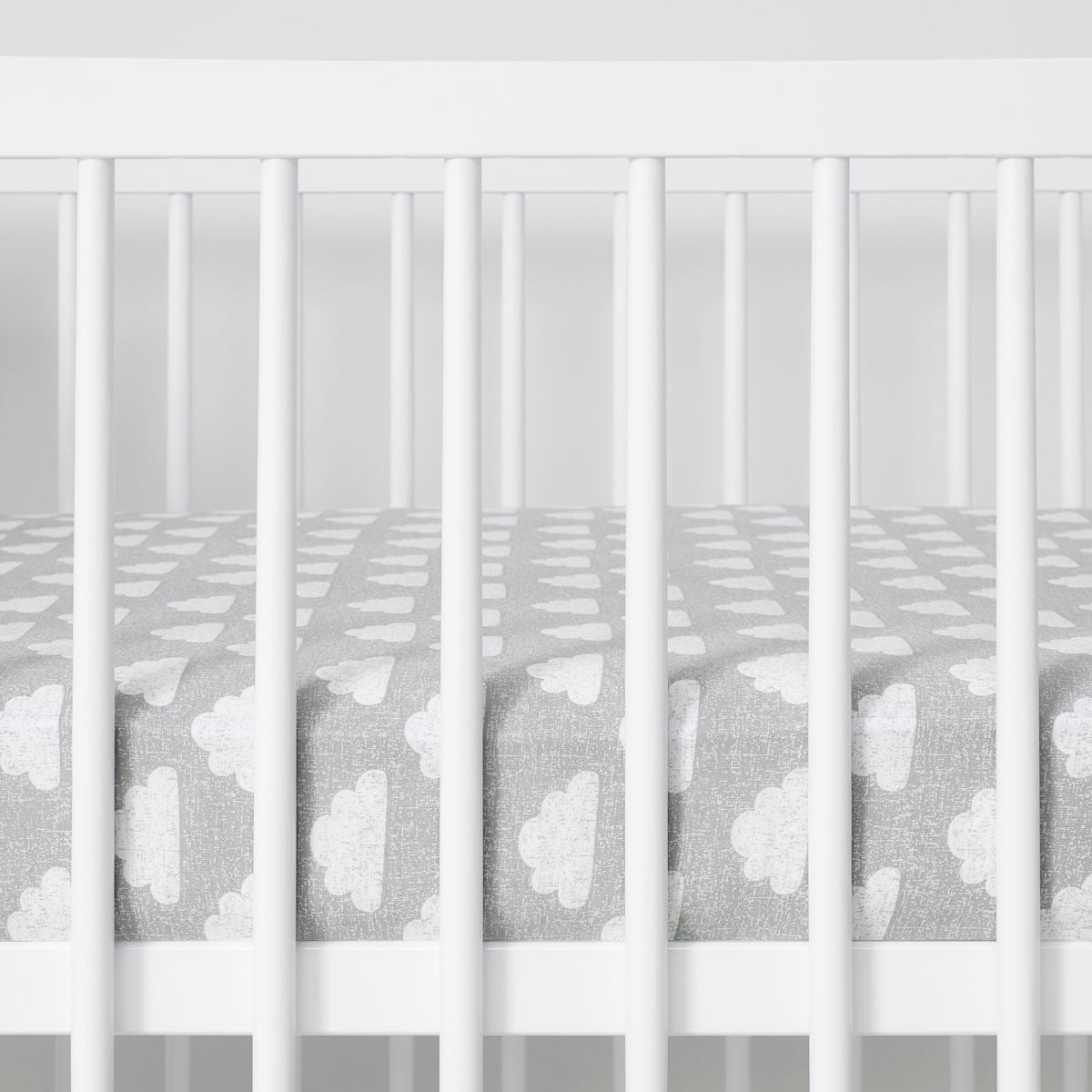 White cot with Cloud Nine sheet featuring white cloud pattern