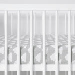 White cot with Cloud Nine sheet featuring white cloud pattern